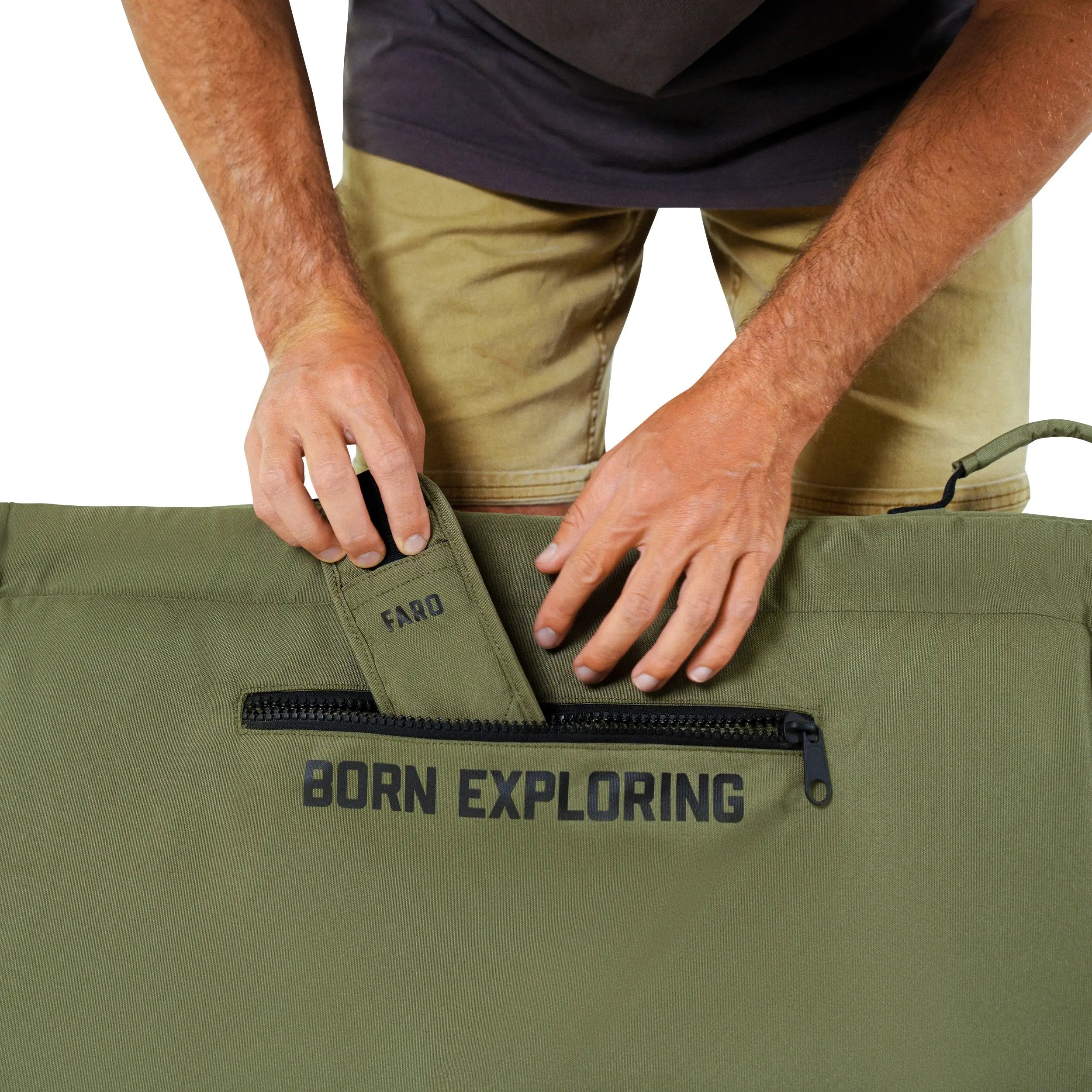 Person holding a green bag with 'Born Exploring' text on a white background