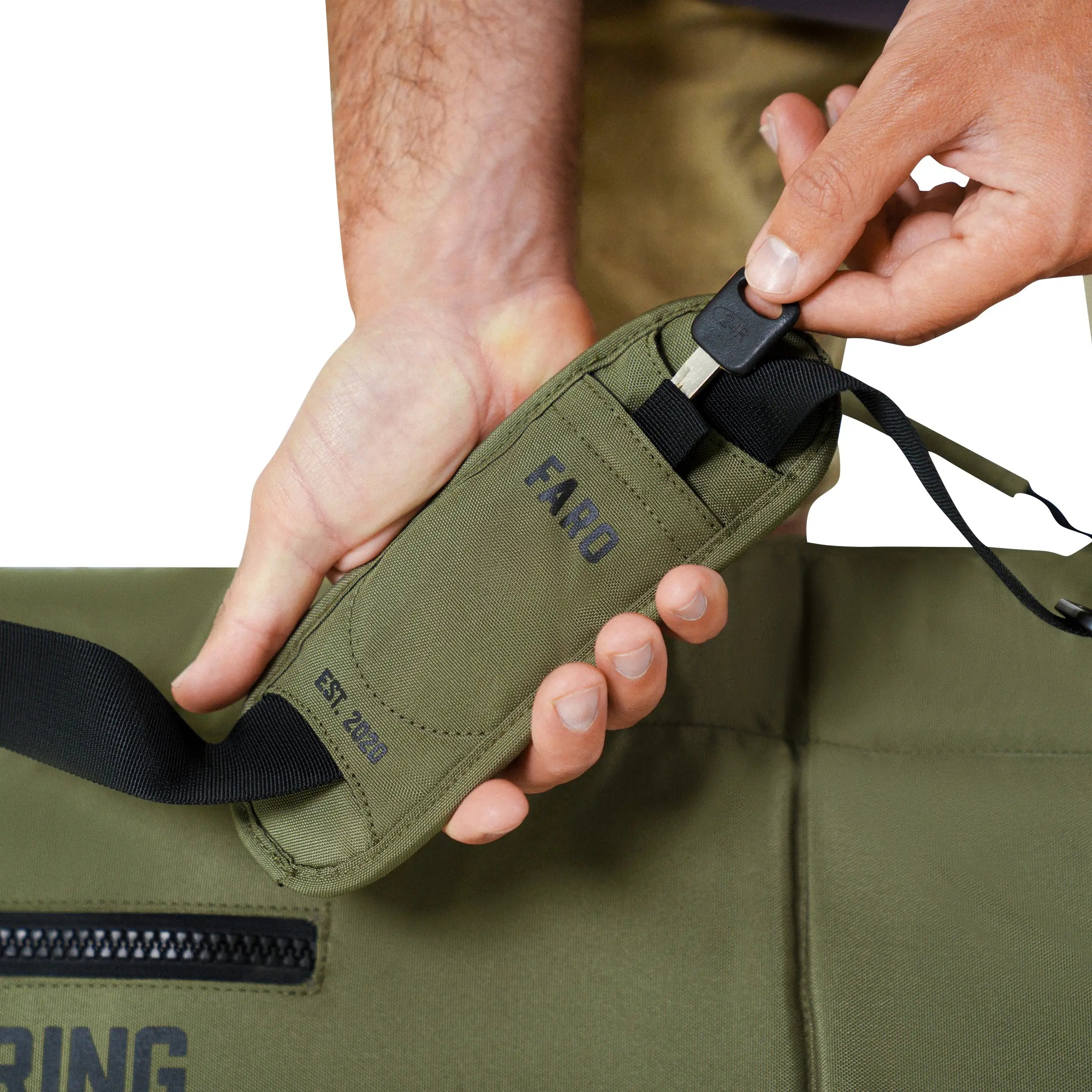 person putting a key into a surfboard bag pocket
