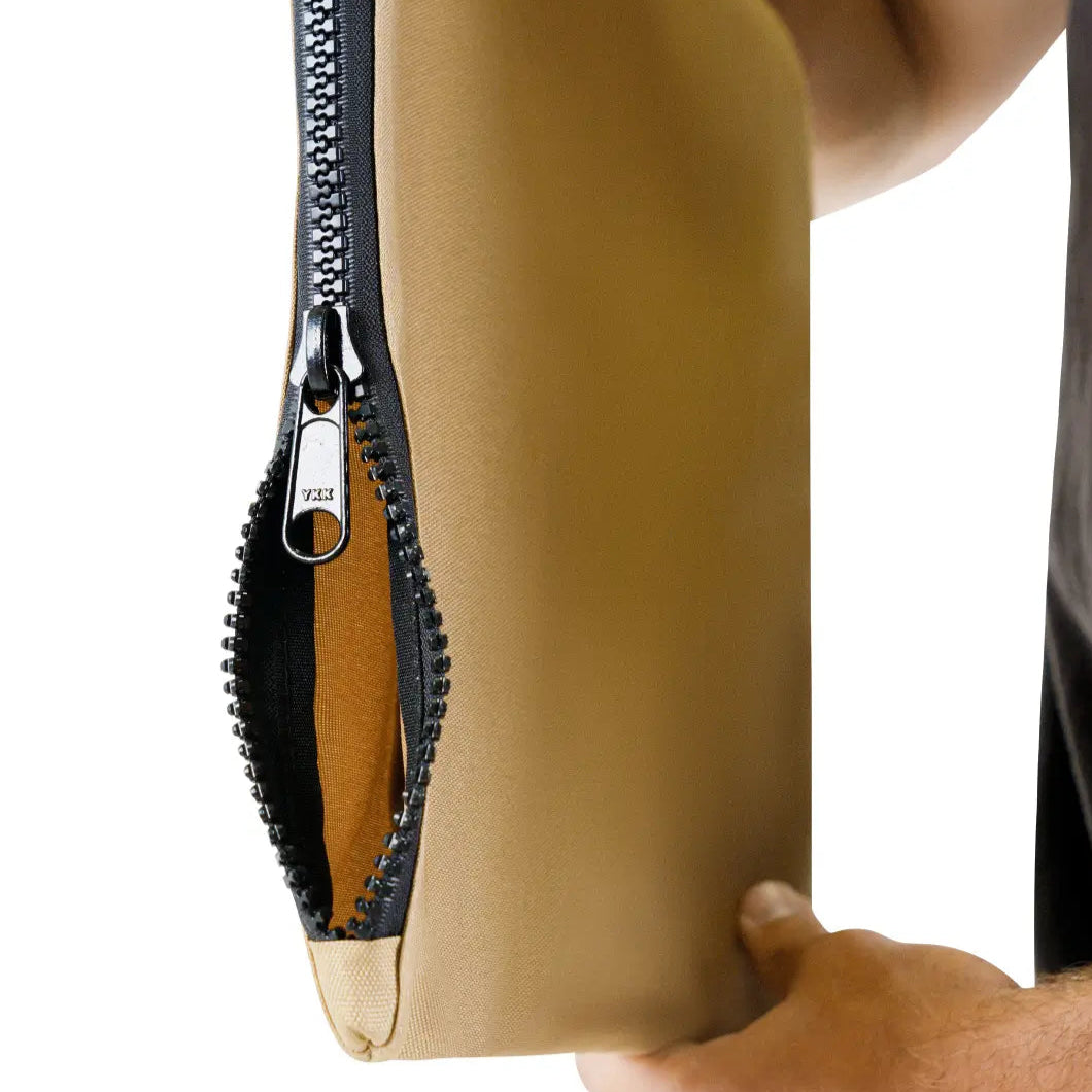 Person holding a beige pouch with a black zipper on a white background