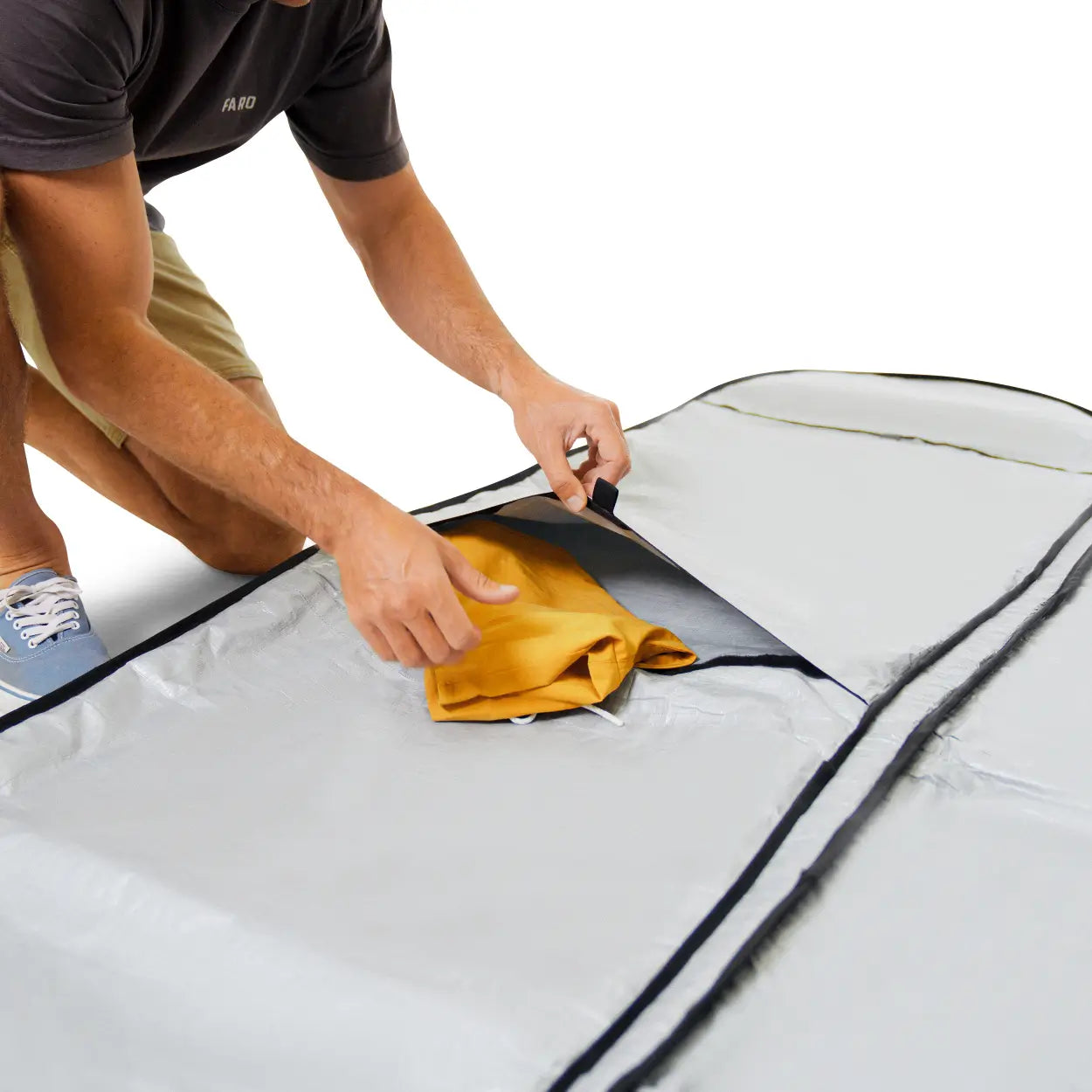 Person packing a surfboard bag